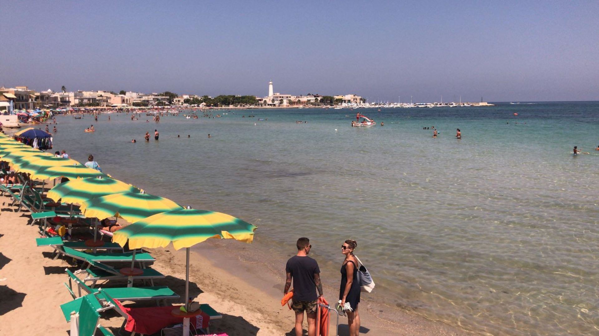 Vista della spiaggia di Torre Canne con sabbia dorata e mare cristallino, ideale per una vacanza di relax e benessere in Puglia