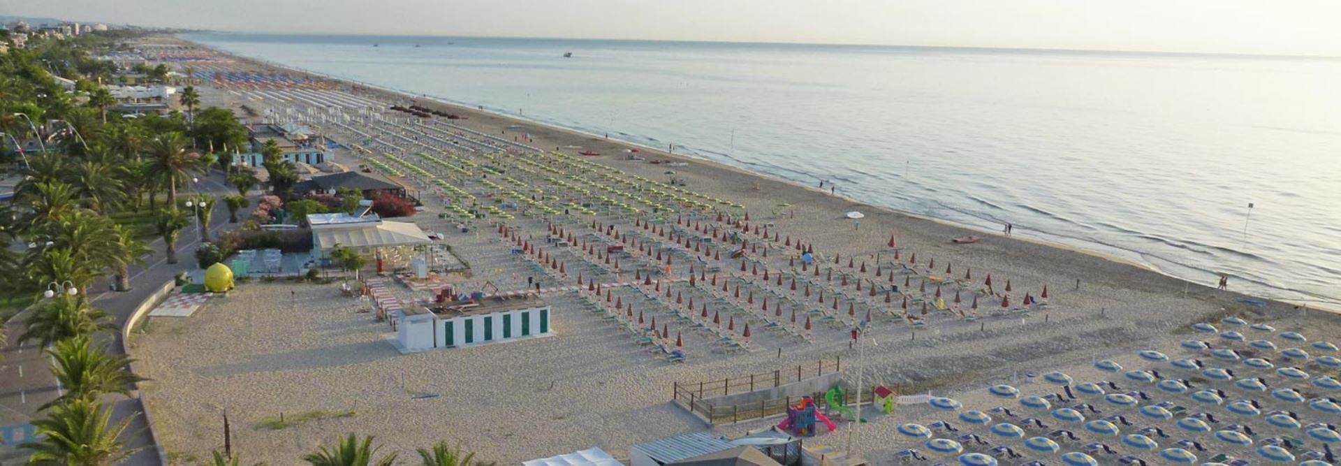 Spiaggia attrezzata di Tortoreto con ombrelloni e lettini, lungo la costa adriatica dell'Abruzzo, ideale per una vacanza al mare in famiglia.