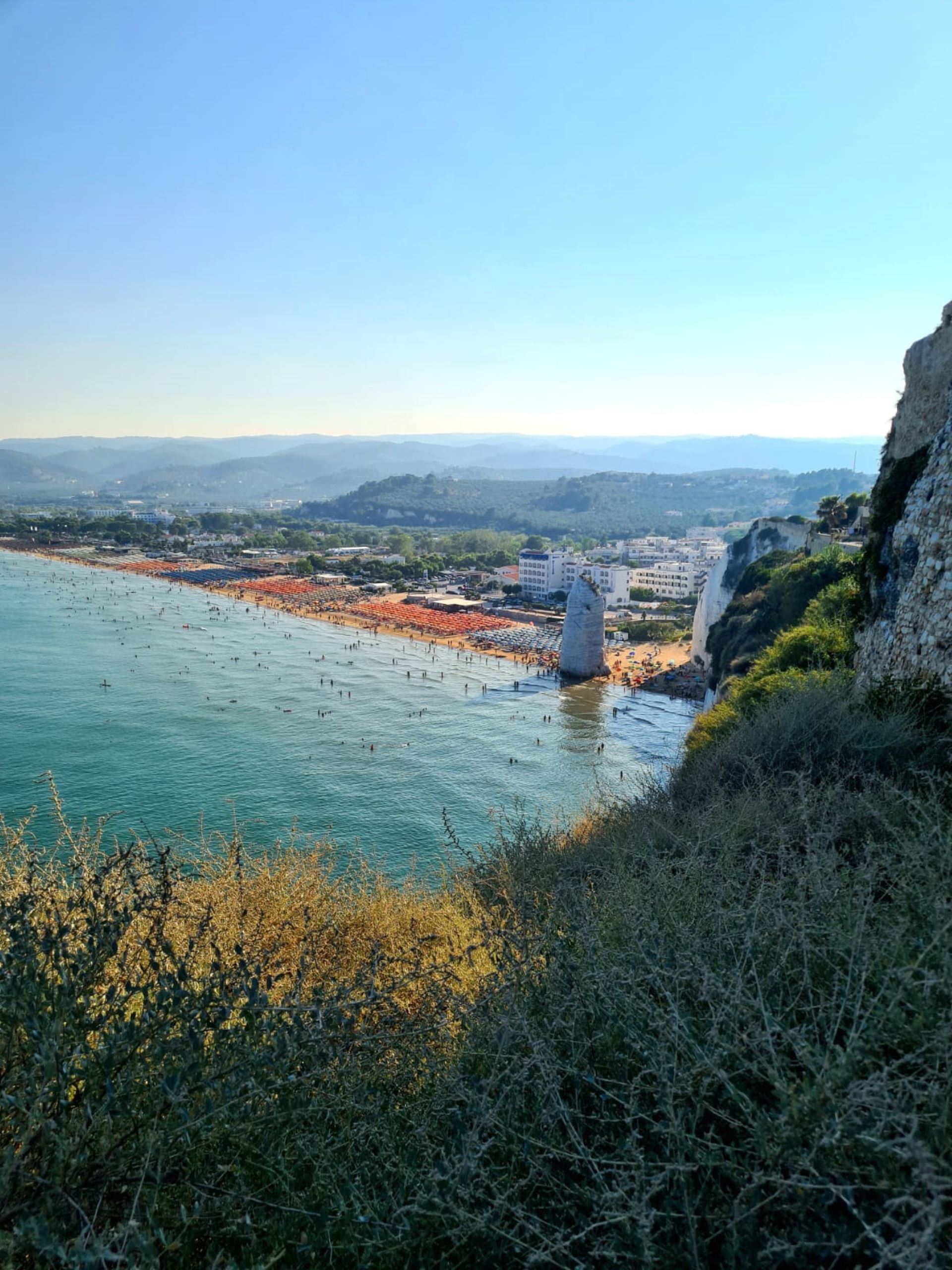 Vista panoramica sulla Spiaggia del Pizzomunno a Vieste, con il famoso monolite bianco e le acque cristalline del Gargano.